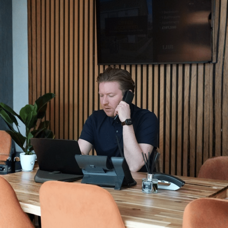 Estate agent speaking on the phone in an office, showing the everyday activity behind micro-content for estate agents