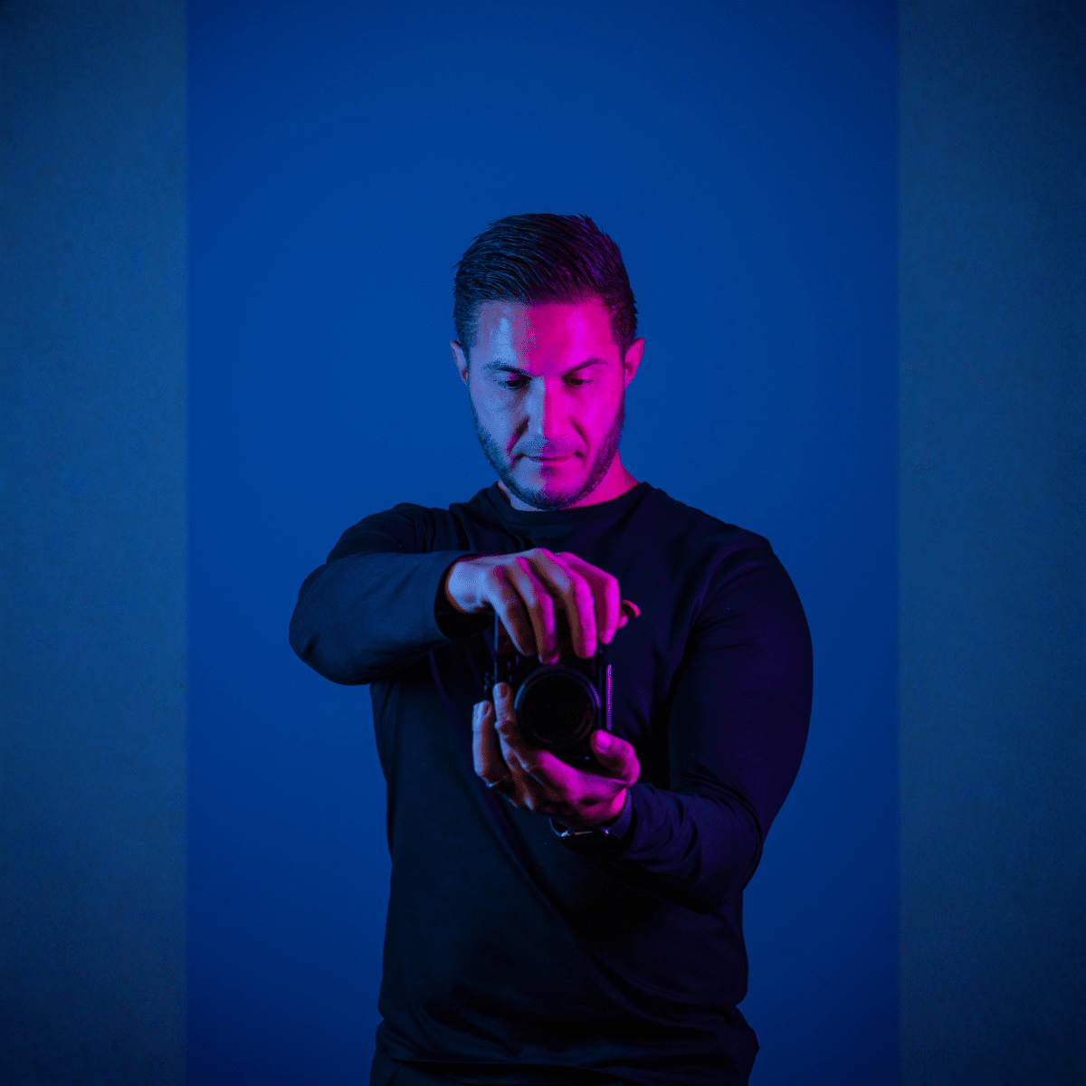Aaron, professional photographer for business at nu media group, adjusting camera lens under studio lighting